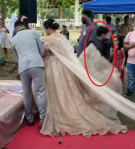 Man hides under brides gown