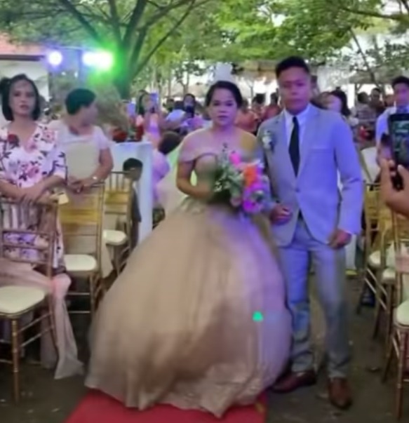 Man hides under brides gown