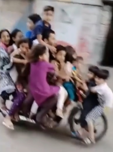 man driving bike with 12 children