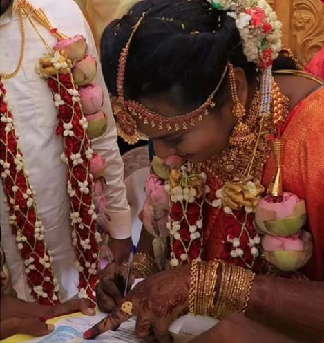 bride signs on bond paper to let her husband to play cricket